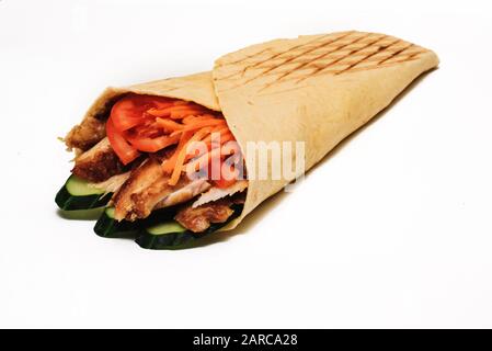 Shawarma isolato con un'ombra. Oriental cibo fatto da carne di pollo, pomodori e cetrioli in pane pita. Foto Stock