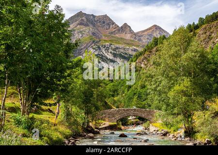 Ponte di pietra sul Gave de Gavarnie. Pirenei francesi, dipartimento di Gavarnie delle Hautes-Pyrenees, Occitania, Francia, Europa Foto Stock