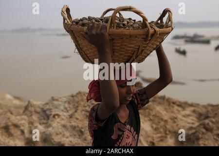 Sylet, Bangladesh. 27th Gen 2020. Suma (10), un lavoro minorile porta pietre raccolte sulla sua testa in un sito di estrazione sulla riva Dholai fiume a Bholaganj, Sylhet. Tutti i lavoratori di età lavorano qui su condizioni molto pericolose senza alcuna apparecchiatura di sicurezza per i salari bassi. Credit: Md Mehedi Hasan/Zuma Wire/Alamy Live News Foto Stock