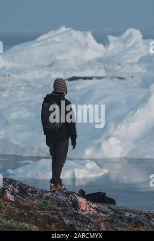 groenlandia turista uomo esploratore che si affaccia Icefjord in Ilulissat. Viaggia nella natura artica del paesaggio con iceberg. Persona turistica che guarda incredibile Foto Stock