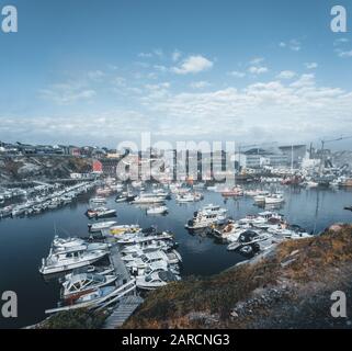 Vista panoramica sul porto e sul porto di Ilulissat, nella Groenlandia occidentale. Piccole barche locali fisher con edifici sullo sfondo. Cielo blu con sole Foto Stock