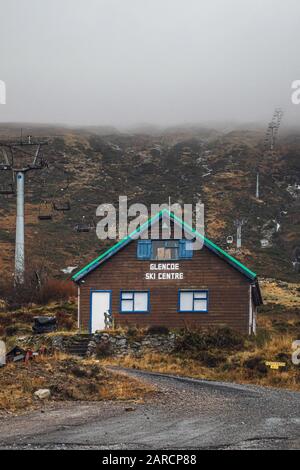 Centro sciistico di Glen Coe mezzo vuoto in una giornata piovosa e bagnata con le colline ricoperte di fitta nebbia. Foto Stock