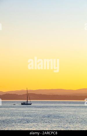 una barca a vela in moto attraverso lo stretto di Haro tra l'Isola di San Juan e l'Isola di Vancouver. Foto Stock