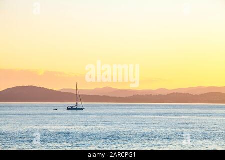 una barca a vela in moto attraverso lo stretto di Haro tra l'Isola di San Juan e l'Isola di Vancouver. Foto Stock