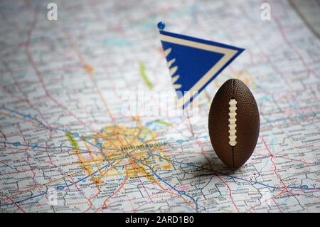 Primo piano di un calcio in miniatura e bandiera posta a Indianapolis, Indiana in una mappa. Foto Stock