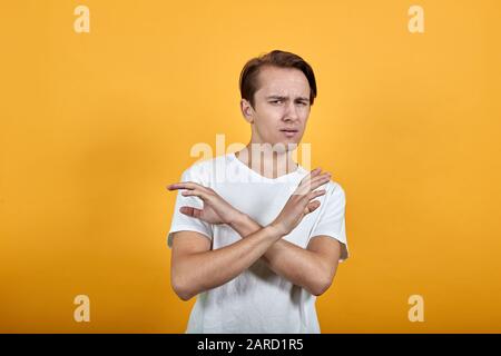 l'uomo in camicia bianca è contro mostrare un gesto negativo con le mani incrociate Foto Stock