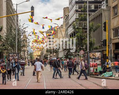 Bogotà, Colombia - 12 settembre 2019: Via di Bogotà con bandiere colombiane, folla di persone e vista della cattedrale sullo sfondo, la Candelaria Foto Stock