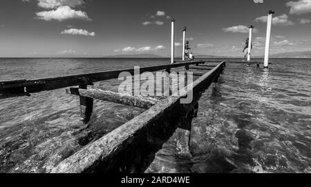 spettacolare immagine del vecchio molo arrugginito sulla costa caraibica con acqua blu utilizzata per la pesca. Foto Stock