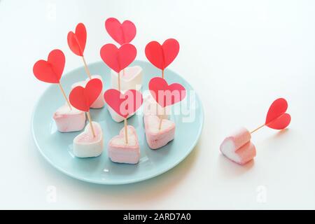 Marshmallows e cuori di carta su spiedini bloccati in meringhe Foto Stock