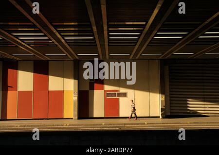 Una donna cammina attraverso la luce del sole vicino all’ingresso del tunnel di Beech Street, la prima strada a emissioni zero del Regno Unito, al Barbican di Londra, Inghilterra, Regno Unito Foto Stock