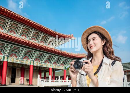 Felice viaggiatore asiatico femminile fotografare templi in Asia Foto Stock