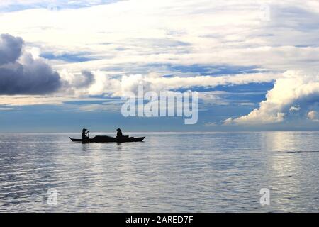 Condimenti minimalisti, silhouette di due pescatori, isola tropicale Filippine, sfondo concettuale Foto Stock