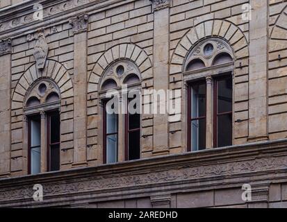 Dettagli architettonici di tre finestre ad arco del Palazzo Rucellai rinascimentale caratterizzano Firenze Toscana Italia Foto Stock