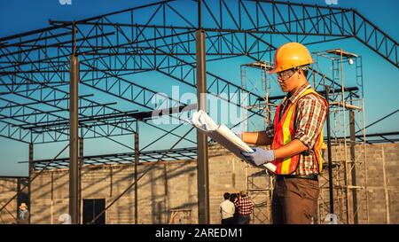 Gli ingegneri si occupano di discussioni con gli architetti che si occupano di piallatura nel cantiere Foto Stock