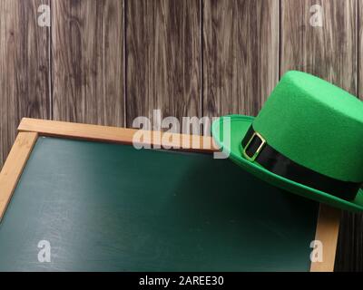 cappello verde su lavagna e sfondo di legno con spazio copia, concetto di giorno di san patrizio Foto Stock