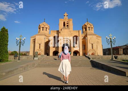 Donna nel Headdress bianco di fronte alla cattedrale di Yerevan, Situata nel distretto centrale di Yerevan, Armenia Foto Stock