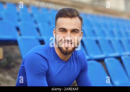 Un ragazzo in sportswear è seduto nello stadio dopo la formazione. Foto Stock