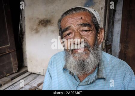 Ritratto di un uomo musulmano anziano e barbuto nell'area di Bhendi Bazar, Mumbai, India, dominata da musulmani Foto Stock