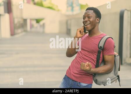 I giovani africani bello uomo turistica zaino porta nelle strade all'aperto Foto Stock