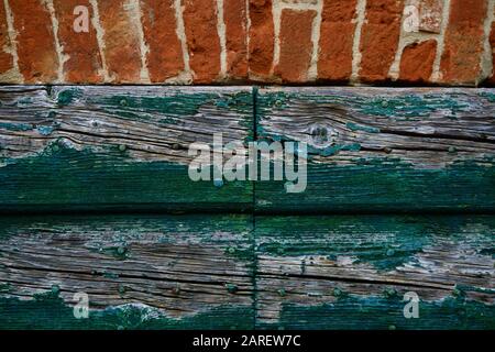 primo piano di una sezione di una porta di legno e mattoni rossi del muro Foto Stock