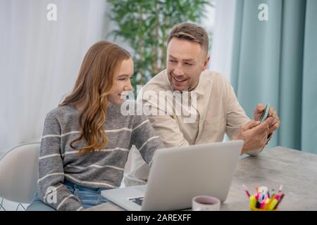 Bearded padre che mostra le immagini alla sua figlia graziosa Foto Stock
