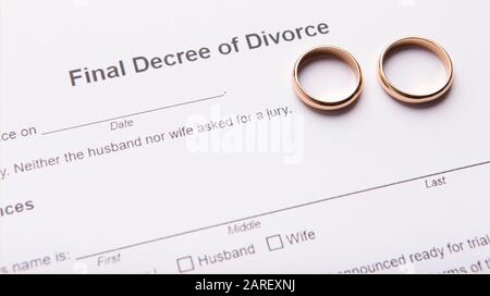 Due anelli dorati di nozze sul documento finale di decreto di divorzio Foto Stock