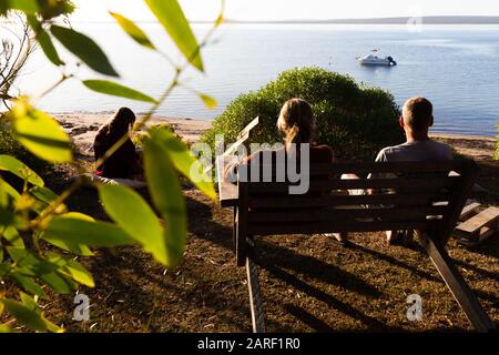 Famiglia con una bella luminosa vista del mattino dal cortile di fronte della casa costiera vicino al mare in Australia. Foto Stock