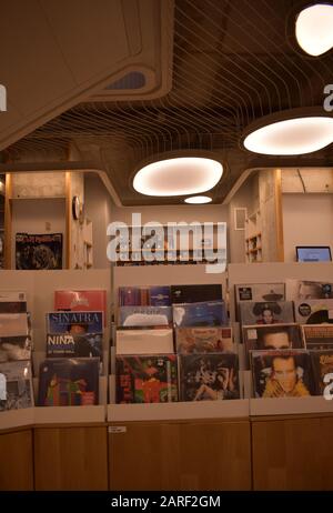 Vecchi album musicali su uno scaffale in una libreria. Grandi luci bianche sul soffitto Foto Stock