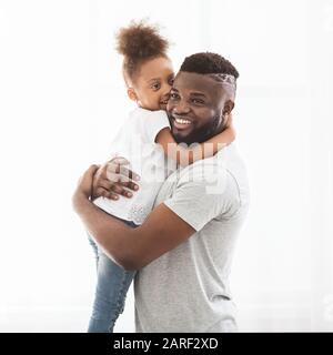 Gioioso afro papà e figlia abbracciando su sfondo bianco Foto Stock