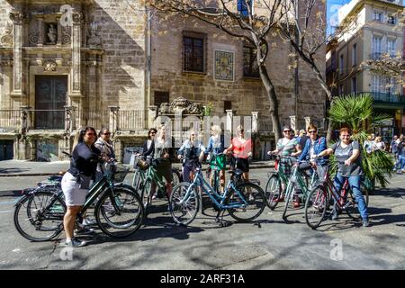 Gruppo di persone, donne in bicicletta, Valencia in bicicletta a noleggio Spagna ciclista in bicicletta Europa turisti di strada visite turistiche Foto Stock