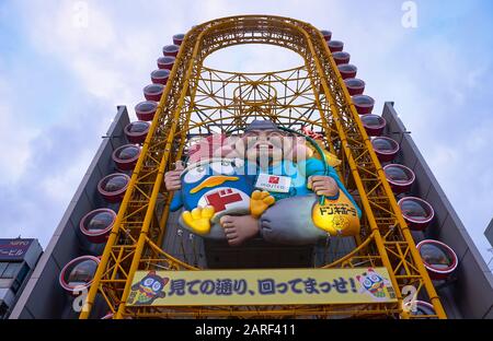 Osaka, GIAPPONE - 14 OTTOBRE 2019: La vista dal basso verso l'alto sull'enorme ruota panoramica gialla, oblunga, del popolare negozio Don Quijote sul canale Dotonbori. Osa Foto Stock