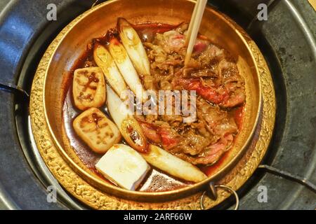 Sukiyaki è un piatto giapponese fatto con carne, verdure, tofu, funghi, tagliatelle e una miscela di dashi, saki, mirin, salsa di soia e zucchero. Foto Stock