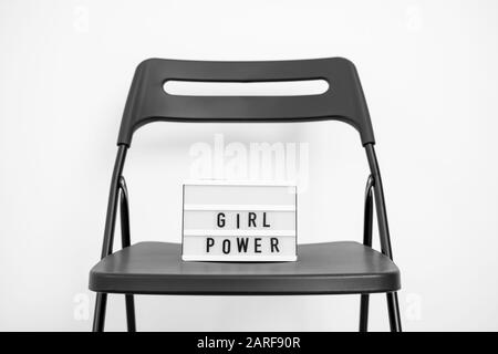 Testo alimentazione ragazza sulla scatola luminosa. Sfondo bianco. Parità dei diritti di genere. Democrazia Foto Stock