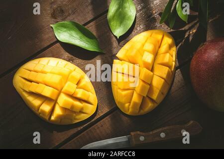Mango dimezzato e cubato. Frutta tropicale su un tavolo di legno. Vista dall'alto Foto Stock