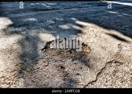 Questa foto unica mostra una pootola in una strada asfaltata grigia. Come spesso simboleggia cautela e pericolo per le strade della thailandia Foto Stock