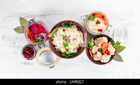 Sauerkraut in un vaso su un tavolo da cucina bianco. Cavolo, cavolfiore. Vista dall'alto. Spazio libero per il testo. Foto Stock