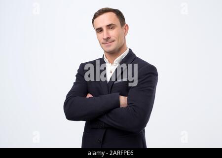 Uomo maturo italiano sicuro con mani piegate che guardano la fotocamera. Professionista e leader del team. Studio Foto Stock