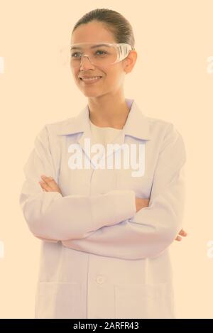 Considerato giovane donna felice medico sorridente indossando occhiali protettivi con le braccia incrociate Foto Stock