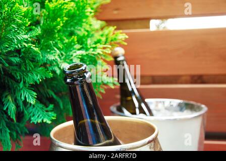 Bottiglie di champagne aperte e chiuse in secchielli di ghiaccio Foto Stock