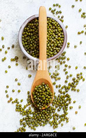 Fagioli bianchi secchi in una ciotola con una vista dall'alto del cucchiaio di legno Foto Stock