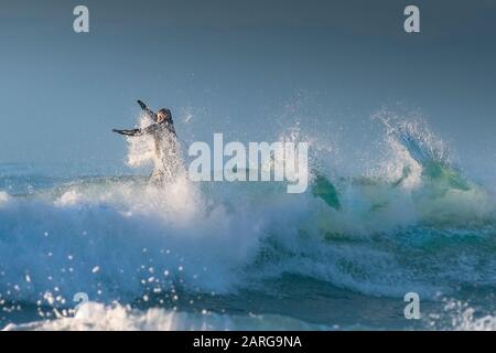 Un surfista in sella a una grande onda a Fistral a Newquay in Cornovaglia. Foto Stock