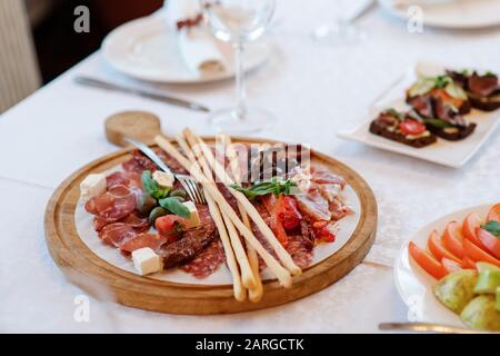 L'originale servizio di prelibatezze mediterranee su un sottile foglio di lavash, su una tavola rotonda in legno. Foto Stock