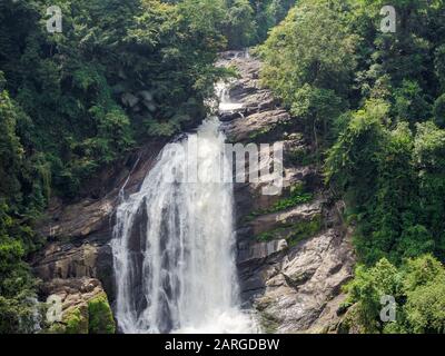 Cascata ripida nella giungla della foresta pluviale indiana in Kerala, India del sud nella giornata di sole Foto Stock