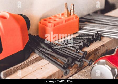 Gli attrezzi per lavorare con una chiave, un cacciavite e un trapano sono situati sul tavolo. Vari attrezzi di Falegnameria. Strumenti per il lavoro. Foto Stock