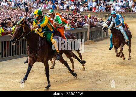 Jockeys in abiti colorati che rappresentano i loro rispettivi quartieri (confcommercio) in vying per la guida al Palio, Siena, Toscana, Italia, Europa Foto Stock