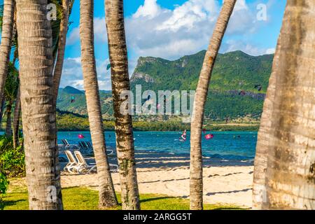 Kitesurf nell'oceano visto dalla spiaggia tropicale con palme, le Morne Brabant, il quartiere del fiume Nero, Mauritius, Oceano Indiano, Africa Foto Stock