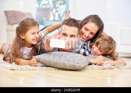 Buona famiglia con due bambini prende un selfie con smartphone Foto Stock