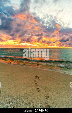 Tramonto africano su impronte sulla spiaggia di sabbia tropicale, le Morne Brabant, Black River, Mauritius, Oceano Indiano, Africa Foto Stock