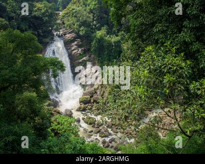 Cascata ripida nella giungla della foresta pluviale indiana in Kerala, India del sud nella giornata di sole Foto Stock