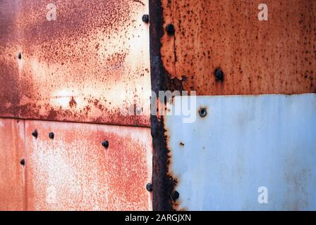 Lamiere arrugginite con rivetti coprono l'angolo del vecchio capannone Foto Stock